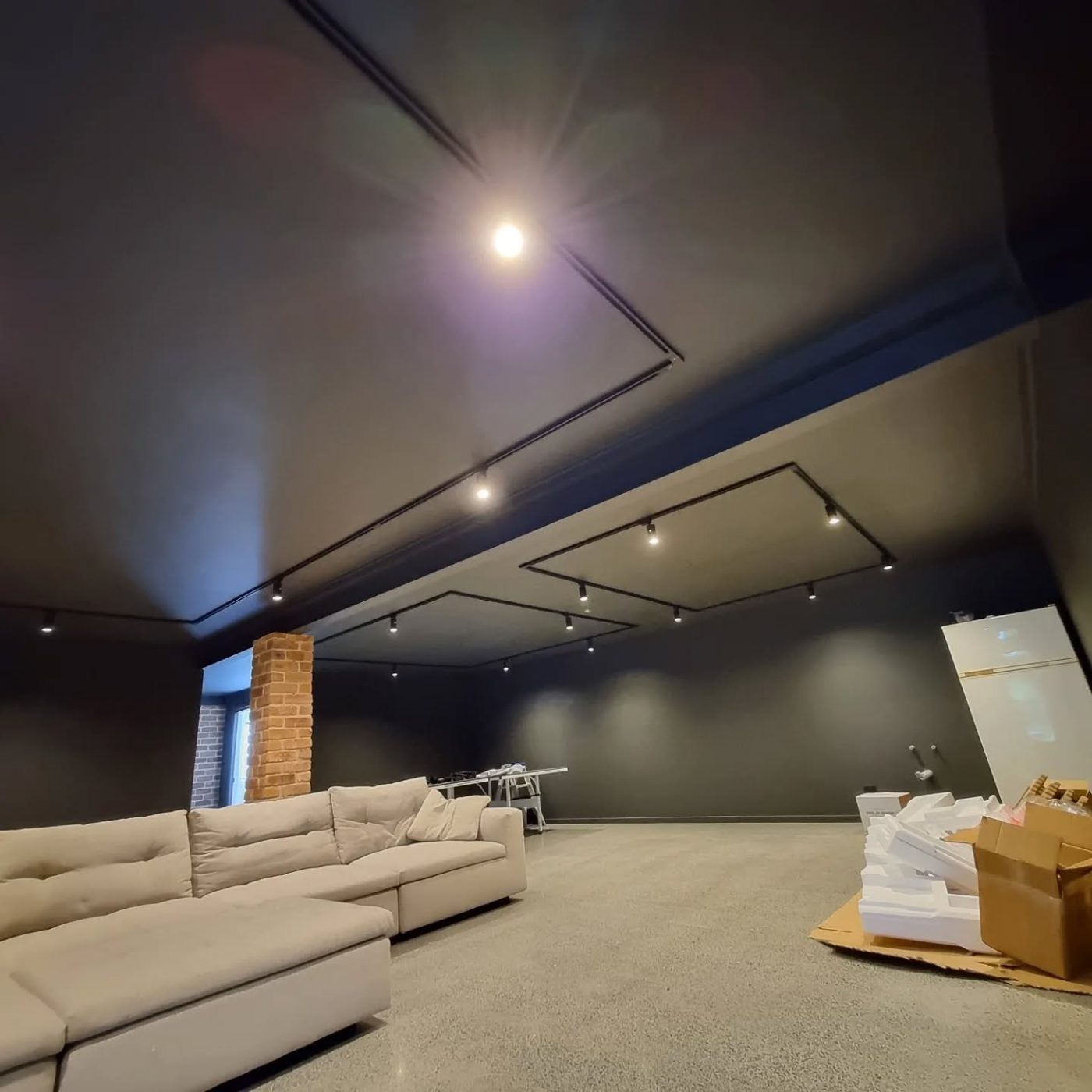 Architectural black track lighting on a dark feature ceiling